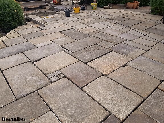 Graue Granitplatten im Römischen Verband verlegt